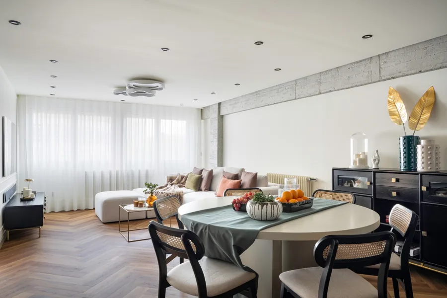 Salón con mesa de comedor y sofá en una vivienda reformada